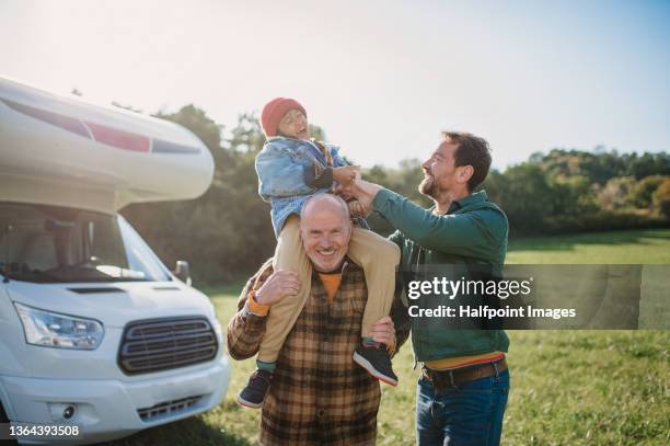 senior man with his grandson and son standing in front of caravan in nature on autumn day. - portrait of a camper stock pictures, royalty-free photos & images
