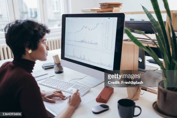una laboriosa donna d'affari latino-americana che osserva alcuni dati e raccoglie alcune informazioni - monitor foto e immagini stock