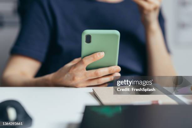 an anonymous person sitting and using its smartphone. - samsung galaxy camera stock pictures, royalty-free photos & images