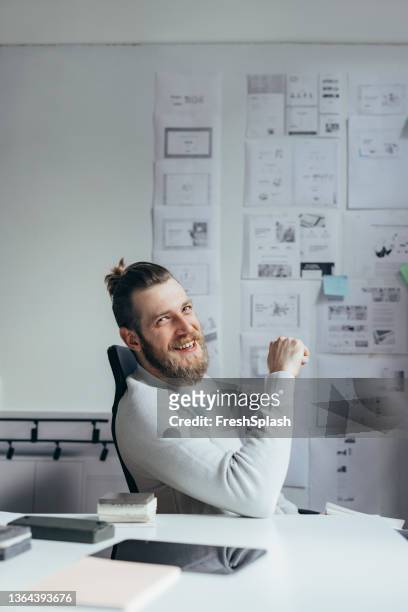 ein gutaussehender mann, der in seinem büro sitzt und einen tag mit einem lächeln beginnt - business people representative smile spontaneous stock-fotos und bilder