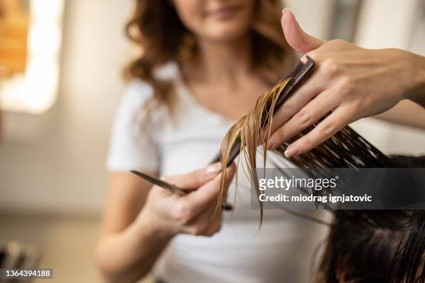close up of unrecognizable female hairdresser, cutting her client hair - hair cut stockfoto's en -beelden