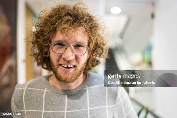 portrait of confident and cheerful young caucasian business person or student at the corporate building or university - spleetje stockfoto's en -beelden