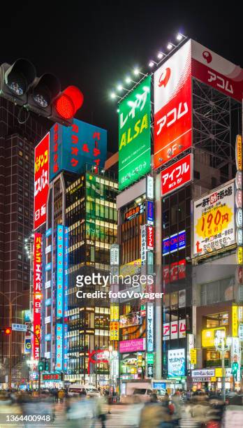 tokyo pedestrians crossing street below neon night billboards shinjuku japan - shinjuku stock pictures, royalty-free photos & images
