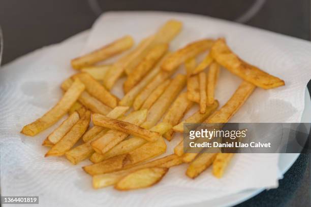 plate of homemade french fries with a blotting paper - aspirador stockfoto's en -beelden