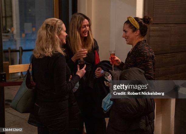 Three women share a drink during an intermission of the performance of Mozart's "The Marriage of Figaro" January 12, 2022 at the Metropolitan Opera...