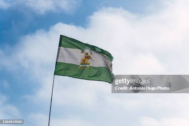 andalusian flag against blue sky. - andalusia fotografías e imágenes de stock