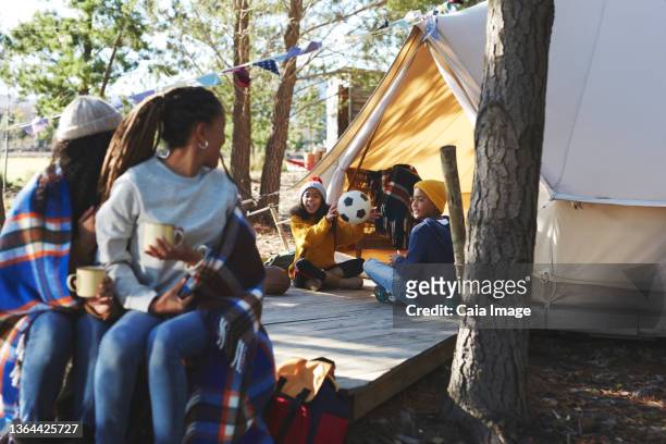 lesbian couple watching kids playing at camping yurt - football wives and girlfriends stockfoto's en -beelden