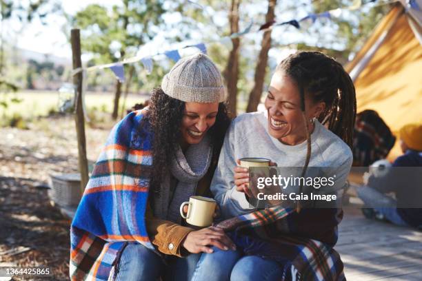 happy lesbian couple laughing, drinking coffee at campsite - funny lesbian 個照片及圖片檔