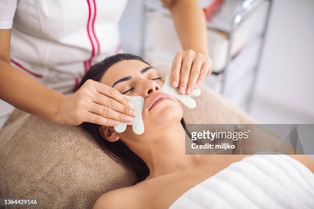 gua sha - traditional chinese massage with stones - spooning stock pictures, royalty-free photos & images