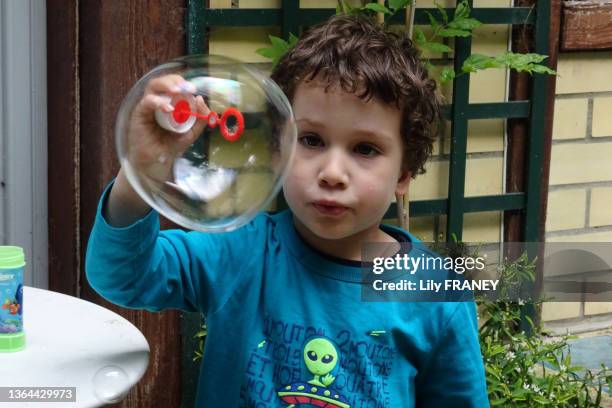 Petit garçon soufflant des bulles de savon le 21 mai 2018 à Paris. MR.