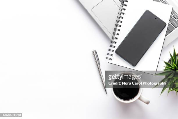 office desk with smart phone, note pad with coffee and laptop - office work flat lay stockfoto's en -beelden