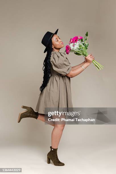 woman holding flowers - frau sommerlich studioaufnahme stock-fotos und bilder
