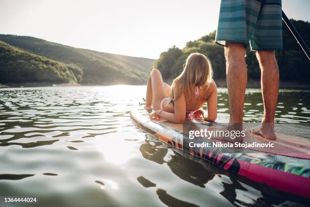 cute young couple paddle boarding and selfie - paddle board men imagens e fotografias de stock