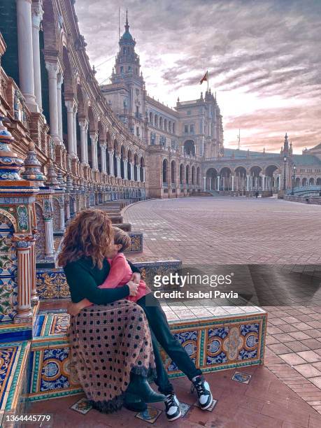 mother hugging son at plaza de españa, seville, spain - seville tiles stock pictures, royalty-free photos & images