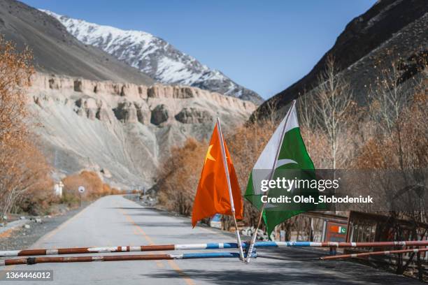 chinese and pakistani flag on karakoram highway - pakistan stock pictures, royalty-free photos & images