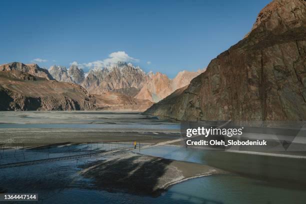 frau zu fuß auf hängebrücke in pakistan - gilgit stock-fotos und bilder