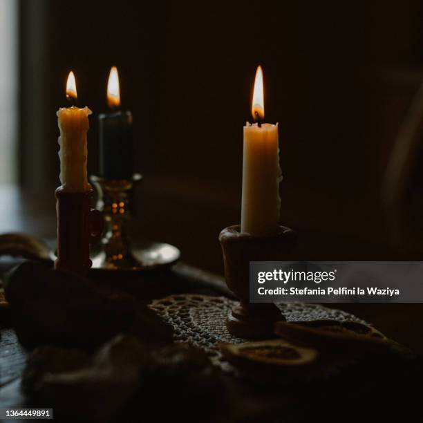 three lit beeswax candles - kerzenschein stock-fotos und bilder