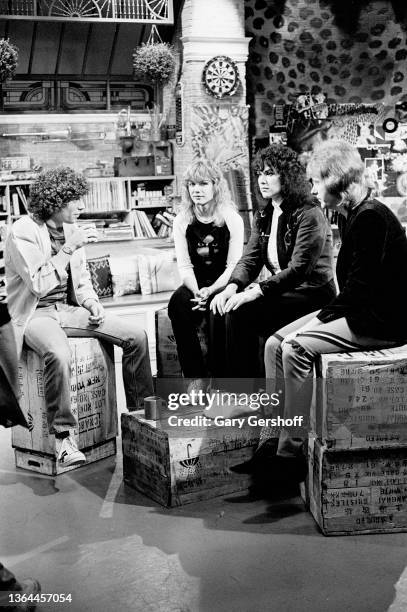 View, from left, MTV VJ Mark Goodman and American Rock musicians Nancy Wilson, Ann Wilson, & Howard Leese, all of the group Heart, as they sit on...