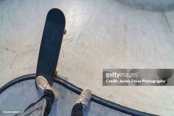 man ready to skate on top of halfpipe in skatepark - semitubo fotografías e imágenes de stock