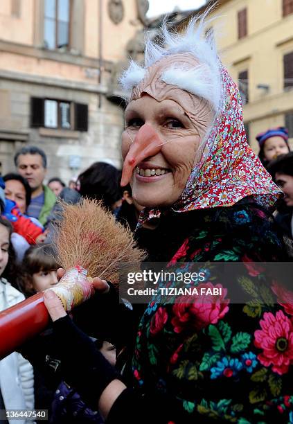 One of the 100 women dressed as the witch Befana carries a 52-metre long stocking full of presents during the annual Befana procession in Viterbo on...