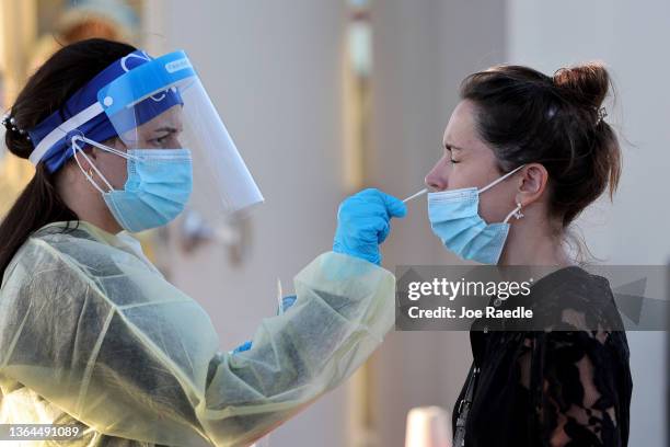 Jordane Domain gets a COVID-19 test done by a healthcare worker on January 13, 2022 in North Miami, Florida. During the holiday surge people waited...