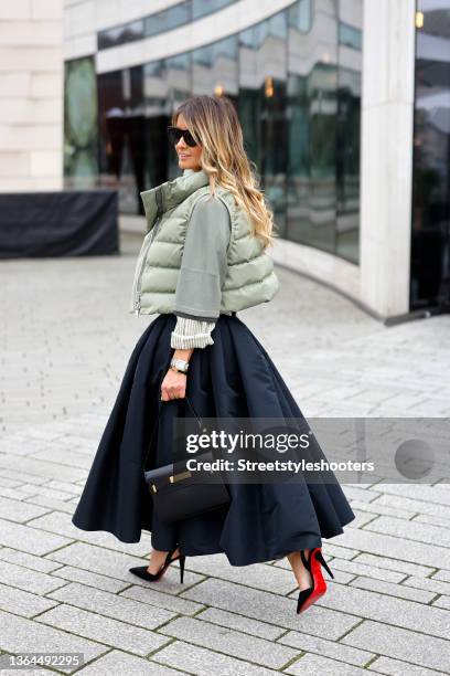 Influencer Gitta Banko wearing a black maxi skirt by Alexander McQueen, a sage green and white striped button down shirt by Brunello Cucinelli, a...