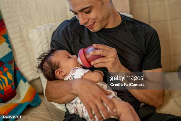 young man caring for baby - dia bildbanksfoton och bilder