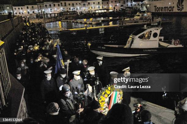 People taking part in a candlelight vigil to mark the exact time that the Costa Concordia cruise ship sank 10 years ago carry a Crown of Flowers in...