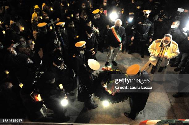 People taking part in a candlelight vigil to mark the exact time that the Costa Concordia cruise ship sank 10 years ago carry a Crown of Flowers in...