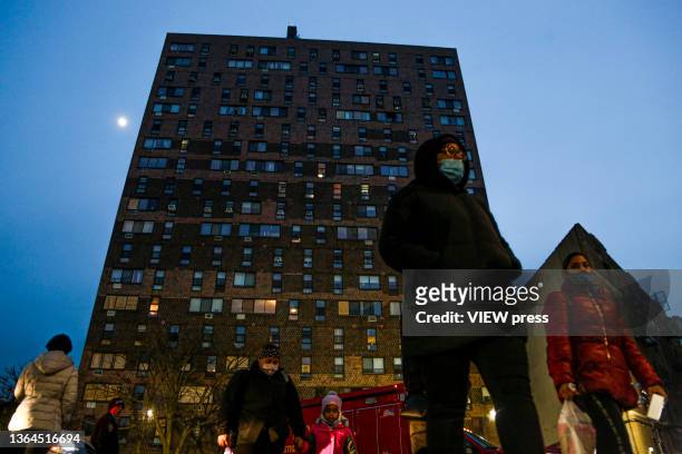 People walk near of the apartment building days after a deadly fire in the Bronx, New York, on January 13, 2022. Officials from the New York City...