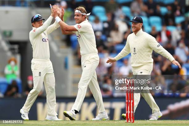 Ollie Robinson, Stuart Broad and Ben Stokes of England celebrate Broad taking the wicket of Usman Khawaja of Australia during day one of the Fifth...