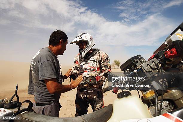 Race oiffical tends to Mauricio Javier Gomez of Argentina and the Paco Gomez Team after he crashed his Yamaha motorbike in a sand dune during stage...