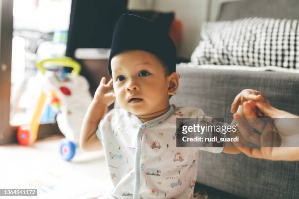 baby wearing a peci hat - muslim boy stockfoto's en -beelden