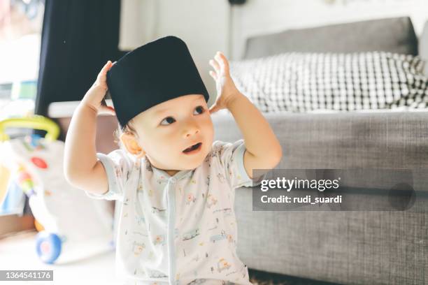 baby wearing a peci hat - muslim boy stockfoto's en -beelden