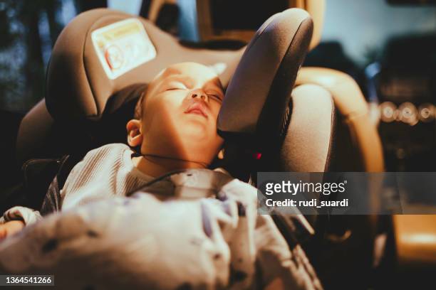babyboy sitzt während der autofahrt in der babyschale - baby night stock-fotos und bilder