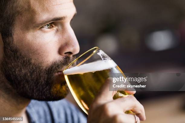 pensive mid adult man drinking beer in a pub. - beer close up stock pictures, royalty-free photos & images