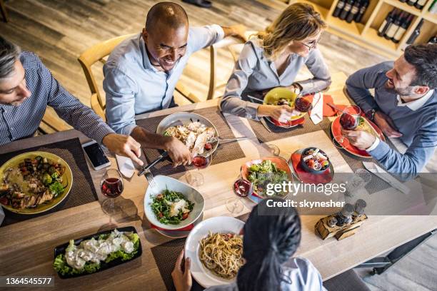 obige ansicht einer gruppe glücklicher geschäftsleute, die sich bei einem mittagessen unterhalten. - business lunch stock-fotos und bilder