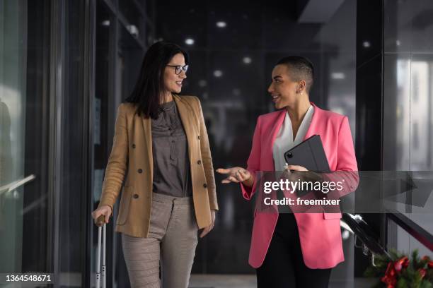 two well dressed women walking and talking in hotel - hotel staff stock pictures, royalty-free photos & images