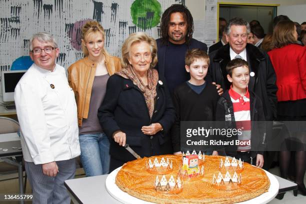 Lorie, Baker Remy Potey, Bernadette Chirac, Christian Karambeu and children pose with a 'Galette des Rois' during the 'Pieces Jaunes' 23rd Campaign...