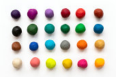 Pieces or balls of Colorful plasticine modelling clay isolated on white background. Top view with shadow. Creativity children toys concept. 24 colors set.