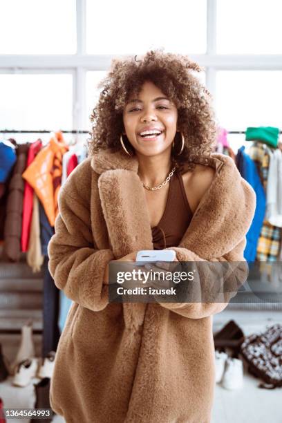 cheerful female influencer wearing fake fur coat - designer shopping stock pictures, royalty-free photos & images