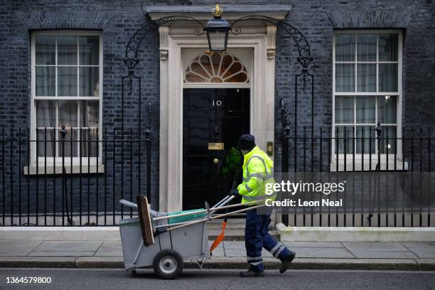 Refuse collector sweeps the road outside number 10, Downing Street on January 14, 2022 in London, England.