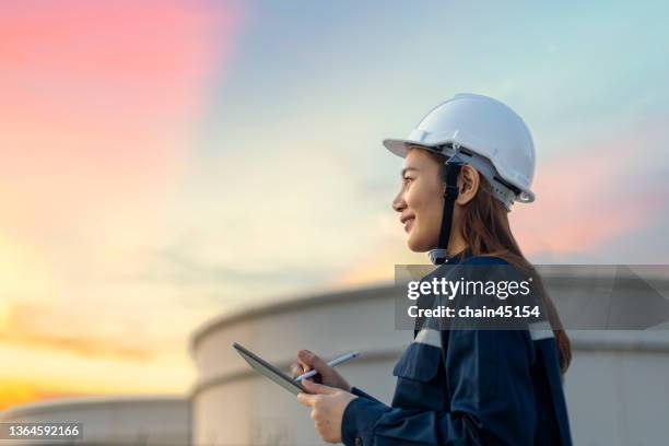 petroleum oil refinery engineer worker in oil and gas industrial with personal safety equipment ppe to inspection follow checklist by tablet. classic energy business concept. - arbeit mit elektrizität stock-fotos und bilder