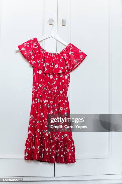 red floral dress on a hanger at home - skirt dress stock pictures, royalty-free photos & images