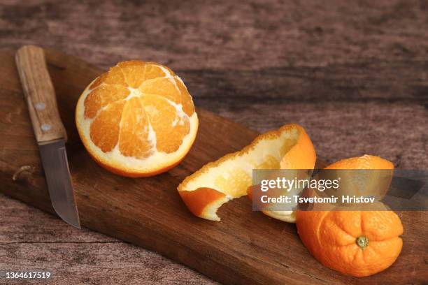 a peeled orange on the wooden background. - peau de fruit photos et images de collection