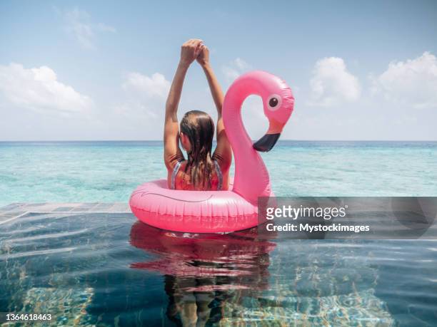 frau genießt luxusurlaub in einem überwasser-bungalow - flamingos stock-fotos und bilder