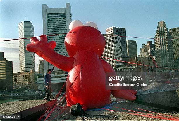 The character Elmo, with a little help from facilities supervisor Johnny Torres, appears to wave to the city from the top of Boston Children's...