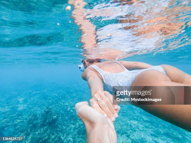 sous l’eau suivez-moi, couple se tenant la main dans le lagon tropical - follow me to man photos et images de collection