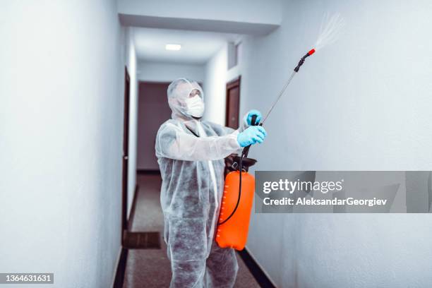 hallway sanitizing by male medical expert in protective suit - white suit 個照片及圖片檔