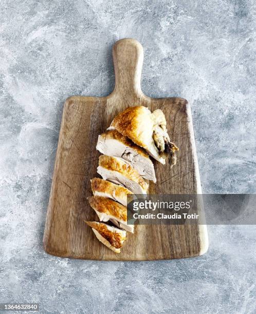 roasted chicken breast on wooden cutting board on gray background - kipfilet stockfoto's en -beelden